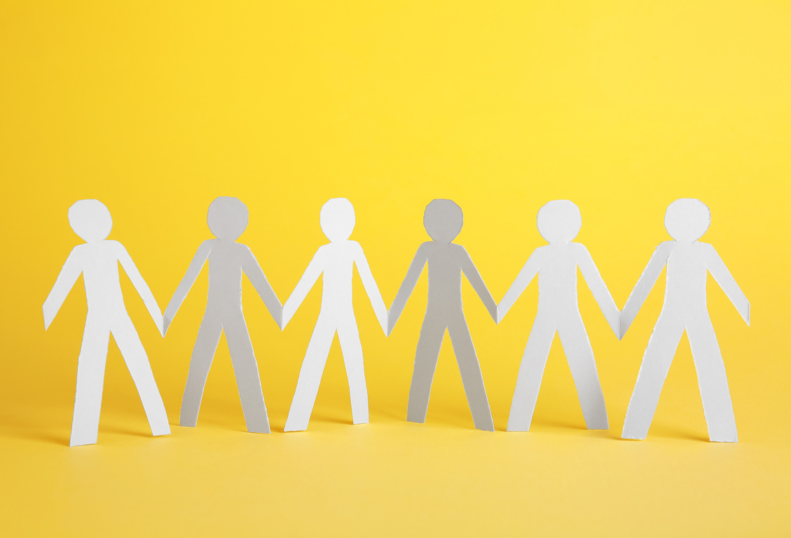 Paper Human Figures Holding Hands on Color Background