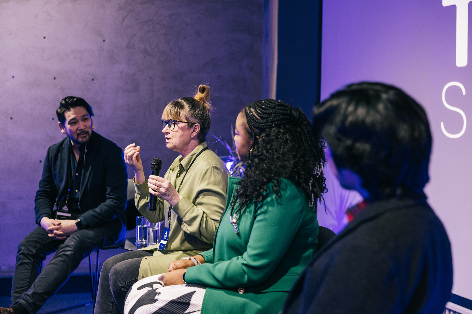 Diverse business people talking during panel discussion at a conference.
